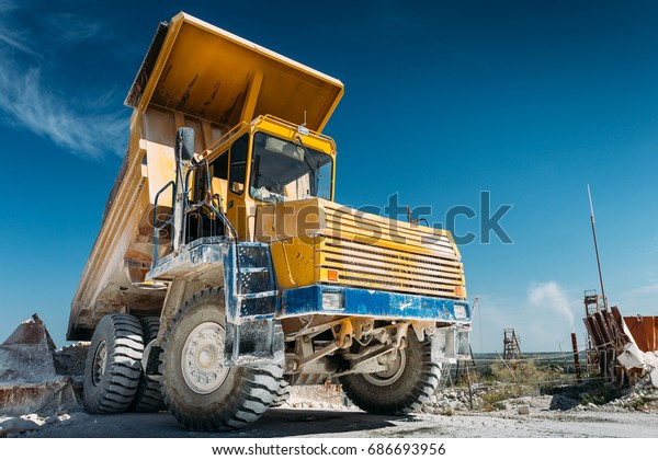 Big\
yellow mining truck vehicle, truck unloads mined ore or chalk or\
limestone. Mining industry concept with copy\
space