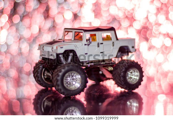 Bigfoot toy car color white, Car radio controller,\
background red BOKEH