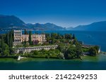 Is the biggest island on Lake Garda. The Venetian neo gothic Villa Borghese Cavazza. Aerial view of the island Garda, Lake Garda, Italy Aerial photography. In the background Alps, blue sky.