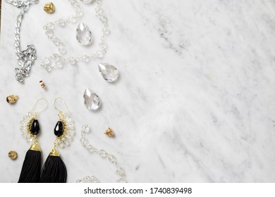 Bijoux flatlay with crafting elements on a white marble table