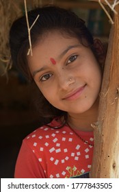 Bikaner, Rajasthan / India-June 03,2020: A beautiful young girl posing under a mud hut posing camera in a rural area of ​​Bikaner.