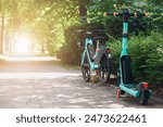 Bike and e Scooter for Rental. Bike Sharing Service.  Eco Transportation in Green City Street. 