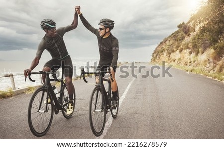 Bike, friends and men high five on road having fun cycling together outdoors. Success, diversity and teamwork of male cyclists on bicycles riding on street, exercise or workout training on asphalt.
