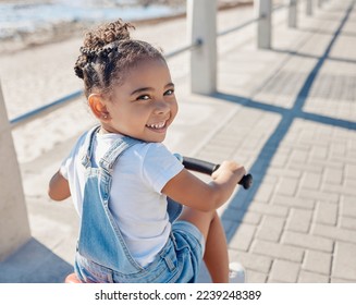 Bike, girl and smile for beach, holiday and outdoor to relax, summer and waterfront. Portrait, cycling and female child enjoy seaside vacation, happy and bicycle for wellness, health and promenade. - Shutterstock ID 2239248389
