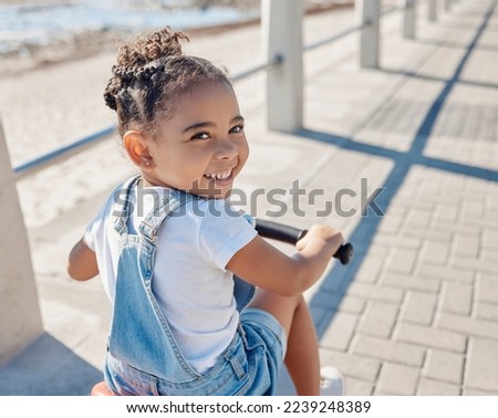 Bike, girl and smile for beach, holiday and outdoor to relax, summer and waterfront. Portrait, cycling and female child enjoy seaside vacation, happy and bicycle for wellness, health and promenade.