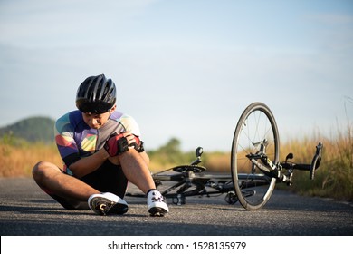 Bike injuries. Man cyclist fell fell off road bike while cycling. Bicycle accident, injured knee.