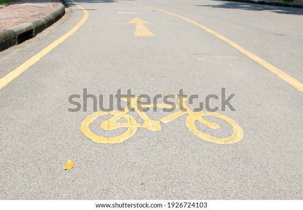 Bike and jogging lanes in the park with bicycle\
yellow label sign on the\
floor