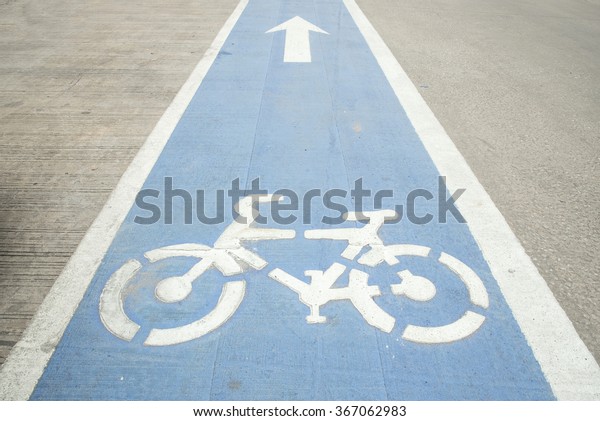 Bike lane, Arrow and bycicle sign on lanes road,\
Bike lane in city street.