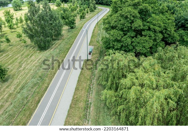 bike lane with footpath in summer\
park. landscape with green trees. aerial drone view.\
