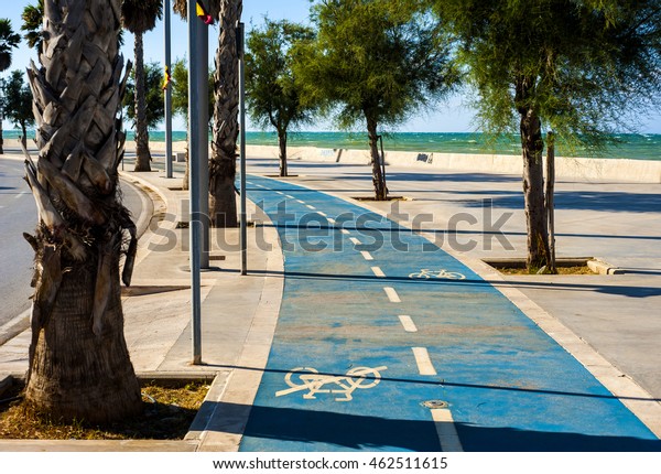 Bike lane sea city. Sign for bicycle painted on the\
asphalt colored. Car and traffic in background. Dividing line,\
diminishing perspective. 
