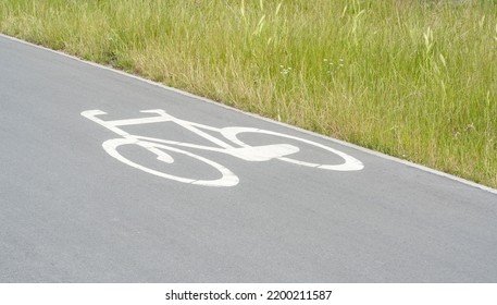 Bike Lane Sign On The Ground, Simple White Bike Symbol Painted On The Path, Road, Closeup Detail, Nobody. Cycling, Biking Designated Areas In The City, Cycle Lanes Infrastructure Concept, No People