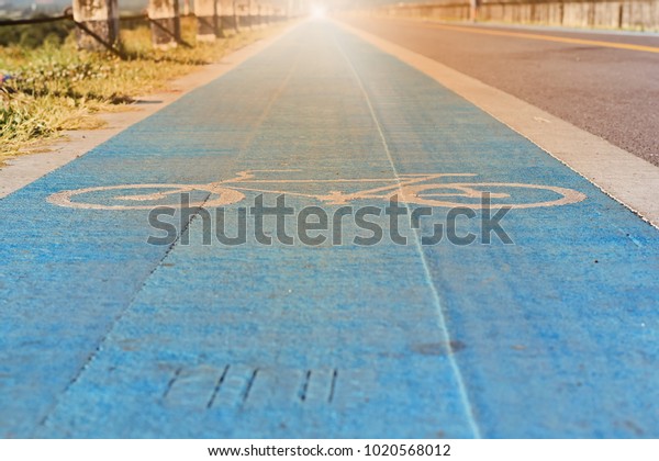 The\
bike lane and bike symbol are on the street with flares as the\
background. Concept for traffic. Selective\
focus.\
