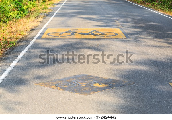 Bike lane warning sign on asphalt\
road to tell that bicycles and cars share the same\
lane