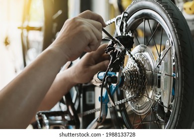 Bike mechanic adjust Rear Derailleur and repair bicycle in workshop. ,bicycle maintenance and repair concept