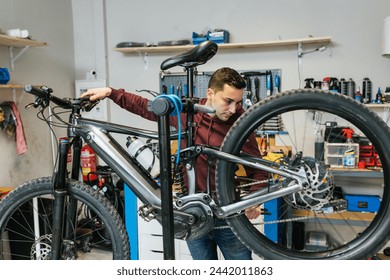 Bike mechanic testing the rear gear shift and brakes of a mountain bike - Powered by Shutterstock