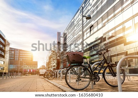 Bike parked near modern apartment residential buiding or college campus at downtown of european city street. Eco-friendly transport and healthy active lifestyle concept. Sustainable work commute