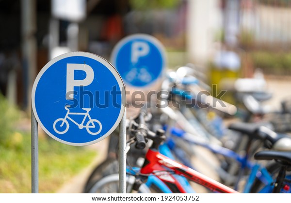 Bike\
parking sign with a blurred bicycle\
background.