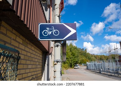 Bike Path Sign On A Pole By A Building.