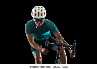 Bike racing. Portrait of female cycling athlete, young woman on road bike bicycle isolated on black studio background. Concept of sport, action, motion, speed, race.