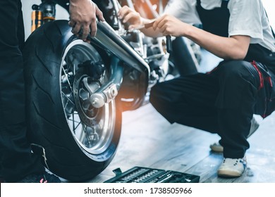 Bike repair. Young man repairing  motobike in garage.mechanic fixing motocycle engine.Serious young man repairing his motorcycle in bike repair shop.