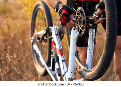 Bike Repair. Young Man Repairing Mountain Bike In The Forest