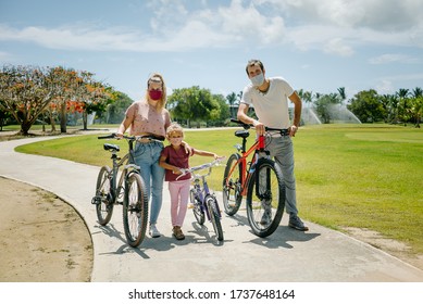 bike ride. family walks in the park on a sunny day. there are seven face masks of different colors on the faces, against the coronavirus covid-19 - Powered by Shutterstock