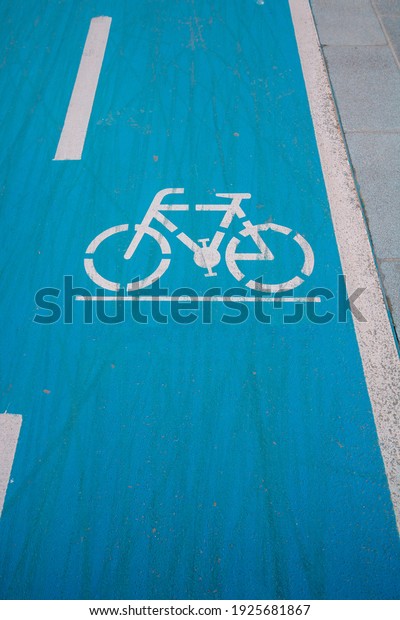 Bike Road sign on the blue background. Healthy\
lifestyle. Bicycle road in the city. Used bicycle track. Bike tire\
tracks on the road.