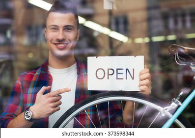 Bike Shop Owner Holding Open Sign
