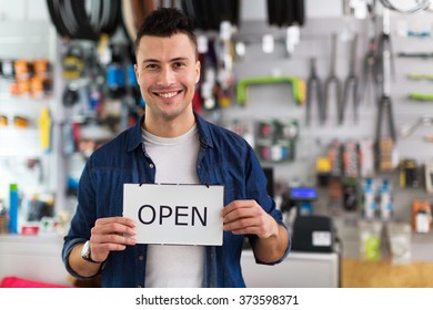 Bike Shop Owner Holding Open Sign
