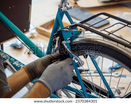 at the bike shop store and repair , old caucasian mechanic expert repairs assembling cargo bicycle