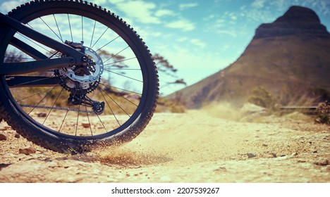 Bike, Sport And Adventure With A Bicycle Wheel In The Dirt For Adventure, Risk Or Freedom And A Mountain In The Background. Bicycle, Track And Sports With A Tyre Turning In The Sand For Fun And Speed