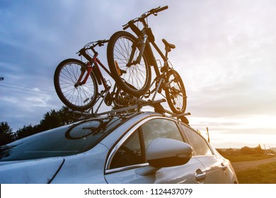 Bike transportation - two bikes on the roof of a car against a beautiful sky. the end of the transportation of large loads and travel by car