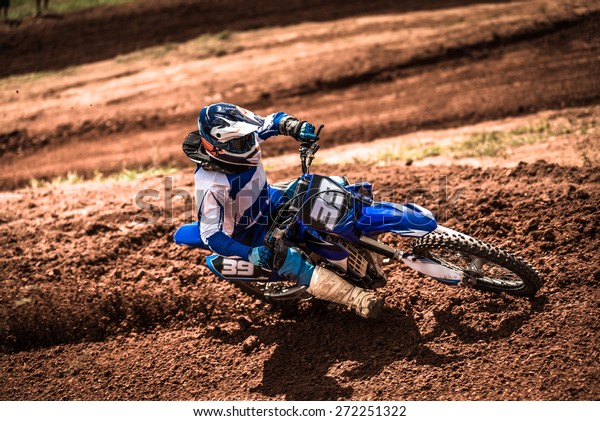 Biker accelerating\
in a motocross dirt track