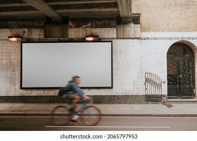 Biker Biking Past Billboard With Design Space On The Street Of London