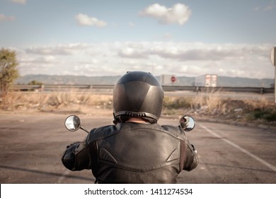 Biker In Black Leather Jacket And Black Helmet, Back View