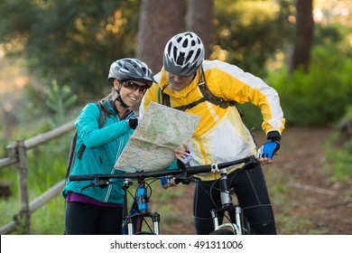 Biker couple interacting over map in countryside - Powered by Shutterstock