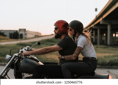 Biker Couple Riding Down The Road In The Sunset