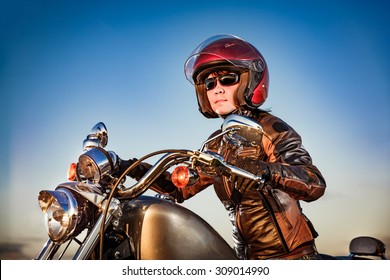 Biker Girl In A Leather Jacket And Helmet On A Motorcycle