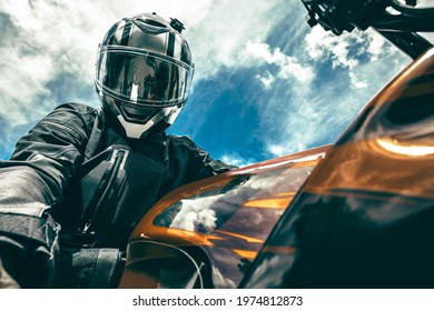 Biker in a helmet sits on a motorcycle against the background of the sky makes a selfie