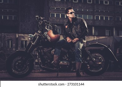 Biker And His Bobber Style Motorcycle On A City Streets 