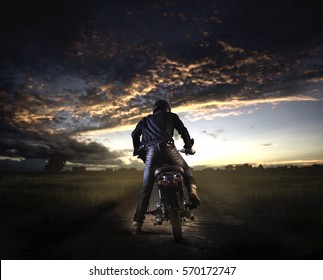 Biker Kick Start Vintage Motorcycle On Country Road.