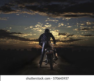 Biker Kick Start Vintage Motorcycle On Country Road.