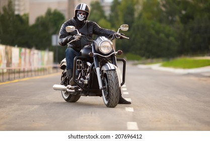 Biker In Mask Sitting Unknown On Big Chopper Bike On Road