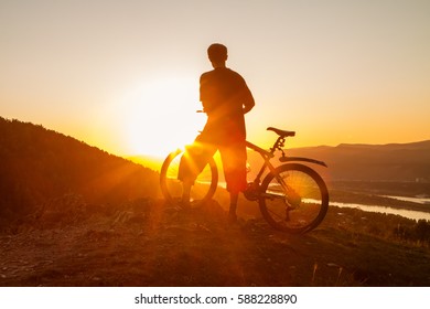 Biker resting while watching sunset