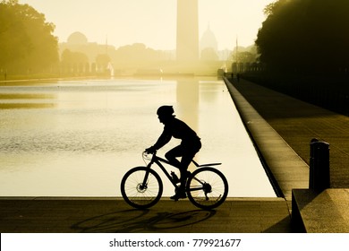 The biker silhouette in a misty sunrise as seen from National Mall - Washington DC, United States