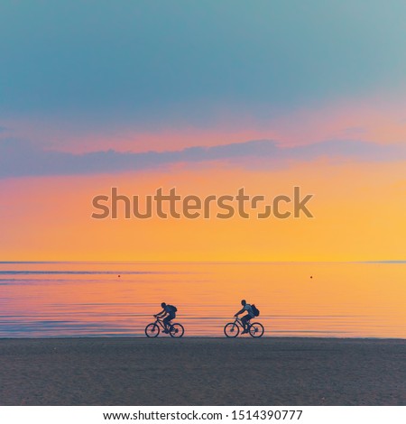 Biker silhouette riding along dune beach at calm cloud sunset view on mtb bike Sporty company group of friends on bicycle outdoors, cyclist mountain biking city park path concept. dad son fit exercise