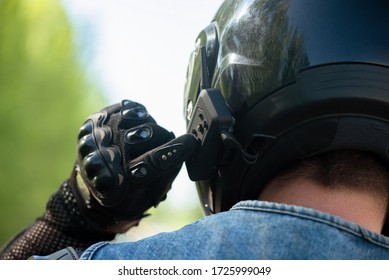 Biker using a intercom radio on his helmet close up.
