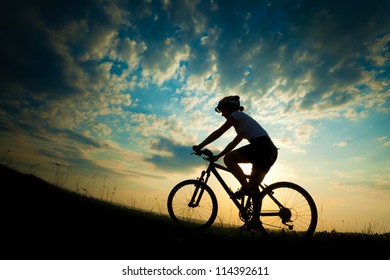 Biker-girl at the sunset on the meadow - Powered by Shutterstock