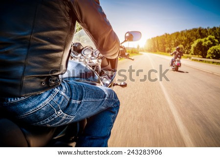Bikers driving a motorcycle rides along the asphalt road (blurred motion). First-person view. Focus on the dashboard of a motorcycle