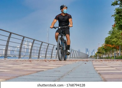 Bikers in front of Dubai skyline during early morning hours. Ride on bike on the road. Sport and active life concept in the summer time.